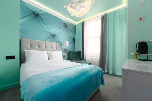 a bedroom with a large bed with blue walls at Starboard Stays Southampton in Southampton
