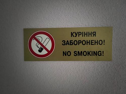 a sign on a wall with a no smoking sign at Guest House MAX in Khmelʼnytsʼkyy