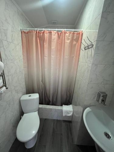 a bathroom with a toilet and a sink at Guest House MAX in Khmelʼnytsʼkyy