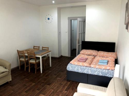 ein kleines Zimmer mit einem Bett und einem Esstisch in der Unterkunft Pleasant apartment with terrace, 1 min. from metro in Prag