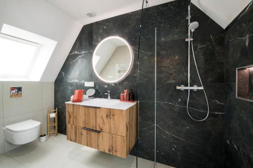 a bathroom with a sink and a shower with a mirror at L'Authentique Spacieux duplex 2 salles de bains in Haguenau