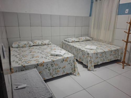 una habitación con dos camas y una mesa en Pousada lagoa azul, en Santo Amaro