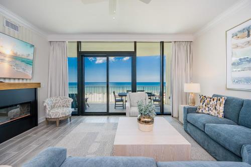 a living room with a couch and a living room with the ocean at Phoenix Gulf Shores II 404 condo in Gulf Shores