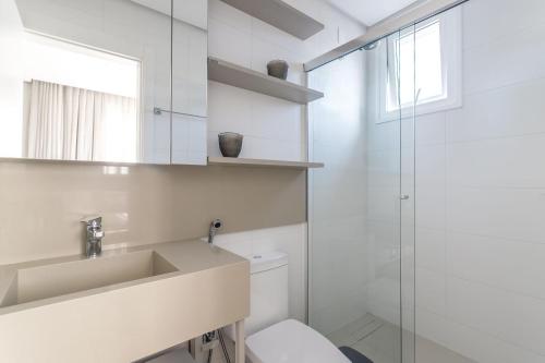 a bathroom with a toilet and a sink and a shower at Apto 2 Quartos com Sacada Ed.Jardim Milano in Florianópolis