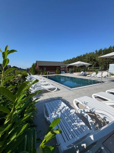 a group of lounge chairs and a swimming pool at Osada Lekranka in Kopań