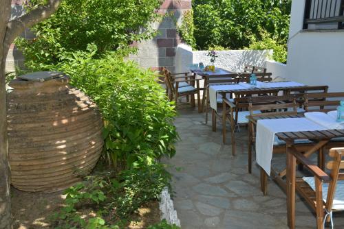 a patio area with tables, chairs, and tables at Hotel Anelli in Skopelos Town