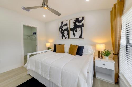 a bedroom with a white bed and a ceiling fan at 3 Mi to Hard Rock Stadium Retreat with Private Yard in Miramar