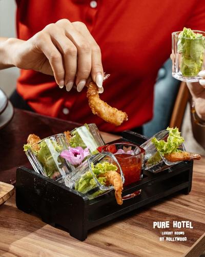 a person is preparing food on a tray with food at Pure Boutique Hotel in Baku