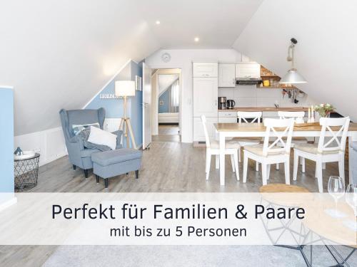 une cuisine et un salon avec une table et des chaises dans l'établissement Lotsenbude Fehmarn, perfekt für Familien & Paare, Nähe Hafen Burgstaaken, à Burg