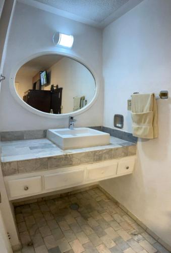 un baño con lavabo y espejo en Hotel Flamingo Kristal, en Irapuato