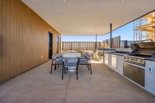a large kitchen with a table and chairs on a balcony at Coral Springs Resort H2 Brand New Home, Community Pool, Outdoor Fireplace, and Near Sand Hollow in Washington
