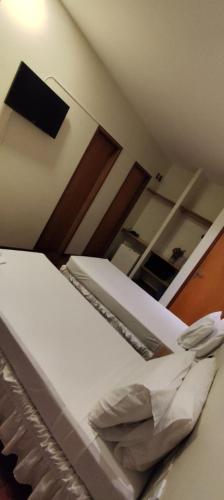 an empty bed in a room with a mirror at Pouso Alegre Hotel INN - Próximo a Unimed e Rodoviária in Pouso Alegre