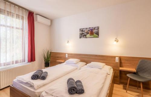 a bedroom with a bed with slippers on it at Citylife Rooms in Mosonmagyaróvár