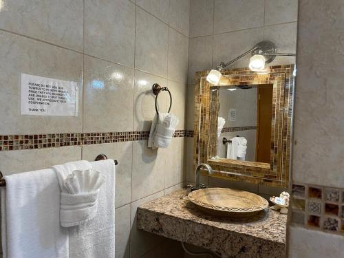 a bathroom with a sink and a mirror and towels at Hospedaje Mulege in Puerto Peñasco