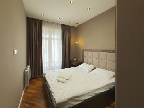 バクーにあるMelissa - Cozy & Great Location in Baku!のベッドとタオル2枚のある寝室