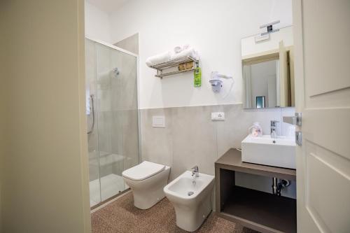 a white bathroom with a toilet and a sink at Dimora Don Ciccillo B&B in Bagnara Calabra