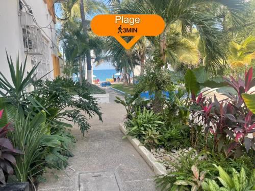 a garden with a sign that says place xymnm at Petit Bonheur - Calm Intimate - Terrace & Beach in Puerto Vallarta