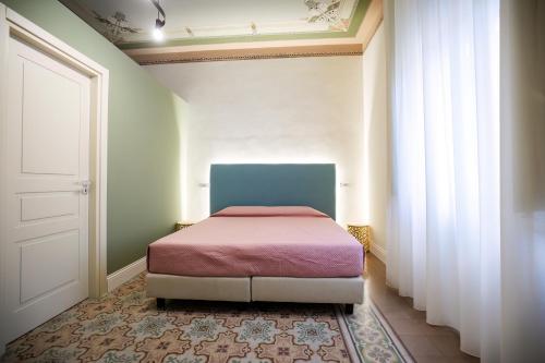 a bedroom with a bed in a room with a door at Dimora Don Ciccillo B&B in Bagnara Calabra