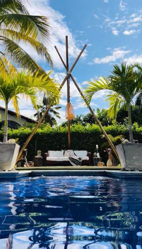 フランデスにあるCoccoloba Hotelのヤシの木が背景に浮かぶスイミングプール