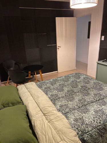 a bedroom with a large bed and a table at Hostel Nueva cordoba Subte Uno in Cordoba