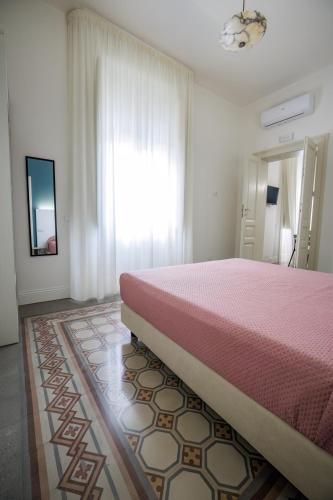 a bedroom with a pink bed and a window at Dimora Don Ciccillo B&B in Bagnara Calabra