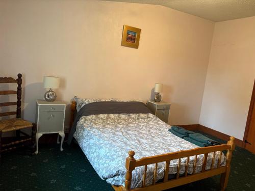 une petite chambre avec un lit et deux tables de nuit dans l'établissement Grange, à Saint-Paul-Mont-Penit