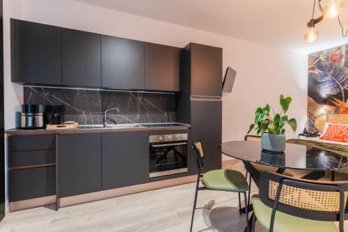a kitchen with black cabinets and a table with chairs at SMERALDO ACQUAMARINA Waterfront in Roseto degli Abruzzi