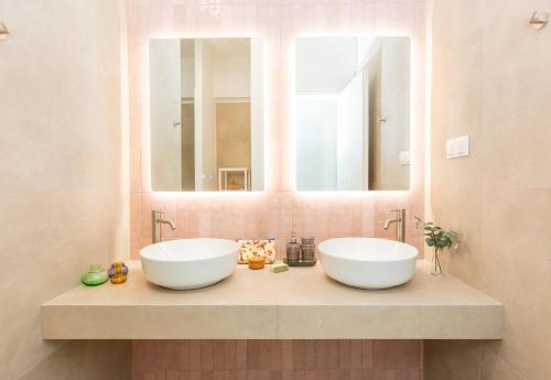 dwie umywalki w łazience z dwoma lustrami w obiekcie Livinn Acropolis View LV w Atenach