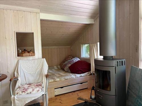 a bedroom with a bed and a stove in a room at 90714-Bogo-By-Hojdedraget-56 in Bogø By