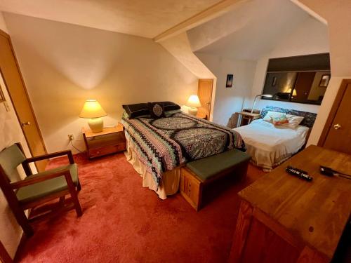 ein Schlafzimmer mit einem Bett, einem Schreibtisch und einem Tisch in der Unterkunft Seven Springs Hideaway Ski In and Out Pet Friendly in Champion