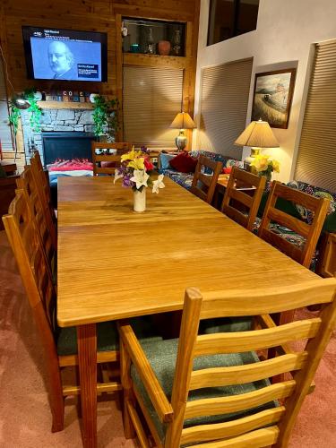 a wooden dining room table with chairs and a television at Seven Springs Hideaway Ski In and Out Pet Friendly in Champion