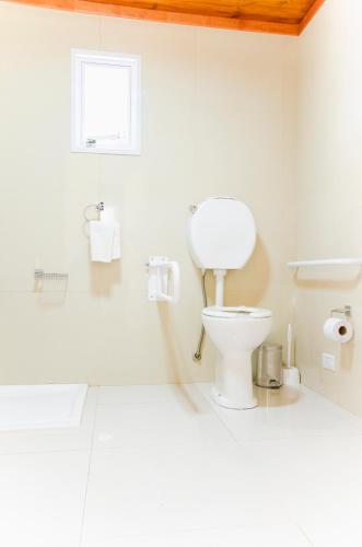 a white bathroom with a toilet and a window at Complejo 21 de Enero - Luz y Fuerza in Puerto Madryn