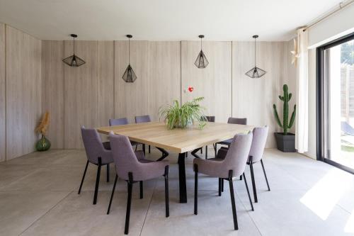 une salle à manger avec une table et des chaises en bois dans l'établissement Villa zen rénovée 4 ch, terrain de basket privé, à Mougins