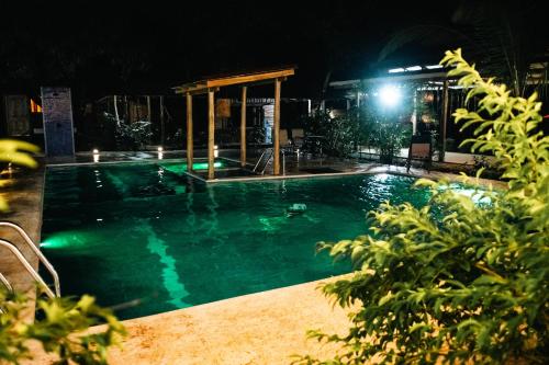 a large swimming pool at night with a lit up at Rusteak Living Retreat in natural and peaceful setting in Canafistula in Cañafístula
