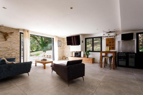 un salon avec un canapé et une table et une cuisine dans l'établissement Villa zen rénovée 4 ch, terrain de basket privé, à Mougins