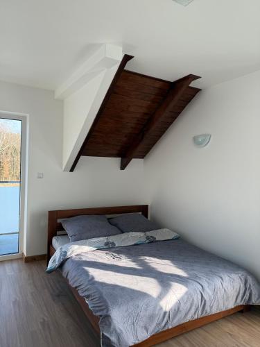 a bedroom with a bed in a white room at Dębowy Dwór, Wędkowanie, Stawy, Agroturystyka in Łagiewniki