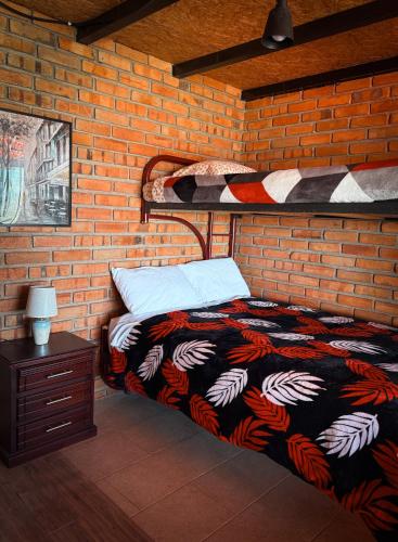 カタマヨにあるCasa familiar La Bendita Rincón Mágicoのベッドとレンガの壁がある寝室