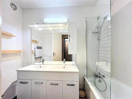 a white bathroom with a sink and a shower at Résidence Pegase - APPARTEMENT 3 PIECES 7 PERSONNES PISTES MAE-9854 in Le Corbier