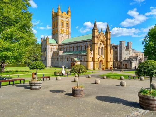 a large building with a clock tower and a church at 2 bed property in Exeter 79431 in Sandford