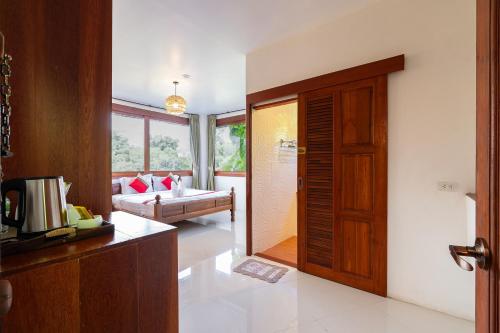 a kitchen with a door leading to a living room at Romsak Lanna Resort in Chiang Mai