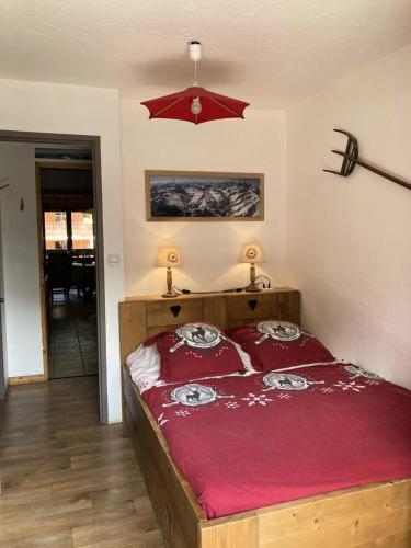 - une chambre avec un grand lit et des draps rouges dans l'établissement Résidence Les Bergers - 3 pièces cabine 6 personnes 3 expo est MAE-4114, à Valloire