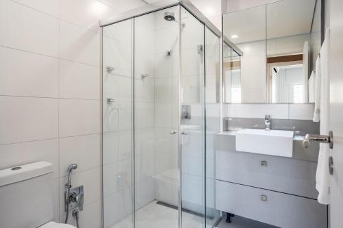 弗洛里亚诺波利斯Apto Centro Florianópolis Prox. Ponte Hercílio Luz的带水槽和淋浴的白色浴室