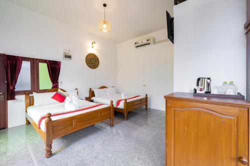 a bedroom with two beds and a sink in a room at Romsak Lanna Resort in Chiang Mai
