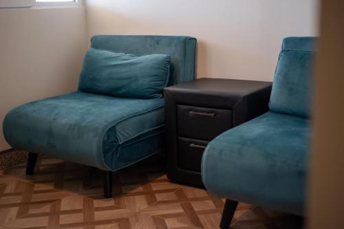 a room with two blue chairs and a stool at TSABAS BEACH SIDE APARTMENTS ΤΣΑΜΠΑΣ παραλιακά διαμερίσματα 1 in Kyllini