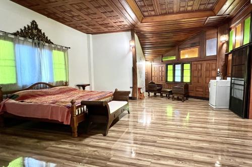 a bedroom with a bed and a tv in a room at Romsak Lanna Resort in Chiang Mai