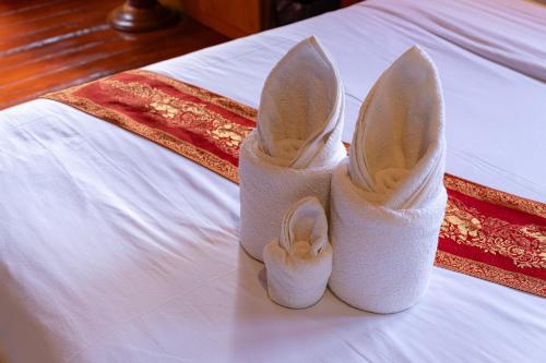 a pair of white shoes sitting on top of a bed at Romsak Lanna Resort in Chiang Mai