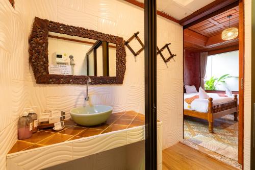 a bathroom with a sink and a mirror at Romsak Lanna Resort in Chiang Mai