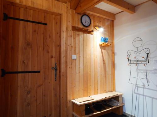 a room with a wooden door and a clock on the wall at Etage Bleu à la montagne in Saint-Julien-en-Champsaur