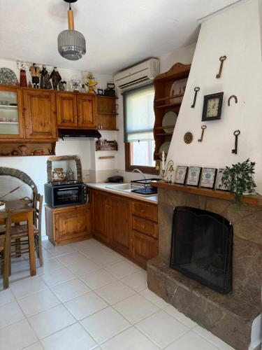 a kitchen with a fireplace in the middle of it at Vigliata Sidirounta Traditional Stonehouse in Chios