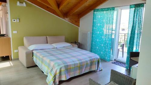 a bedroom with a bed and a large window at Dreaming Feriolo - mansarded apartment by Danilo Apartments in Baveno